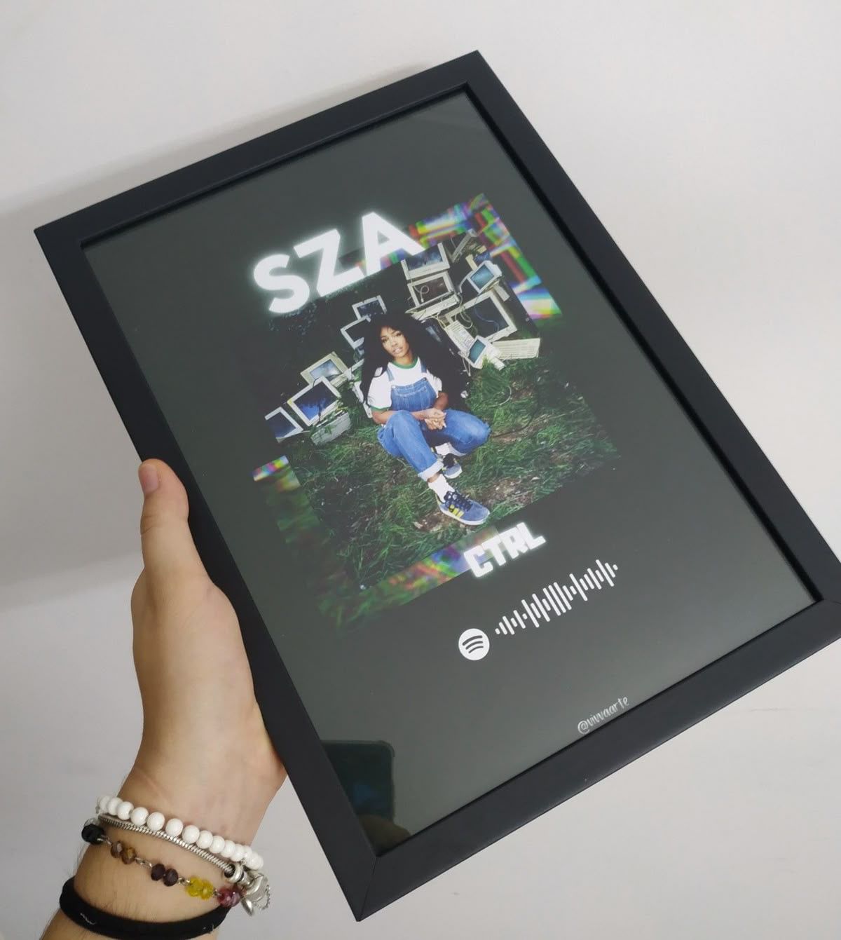 Hand holding a framed SZA CTRL album poster plaque